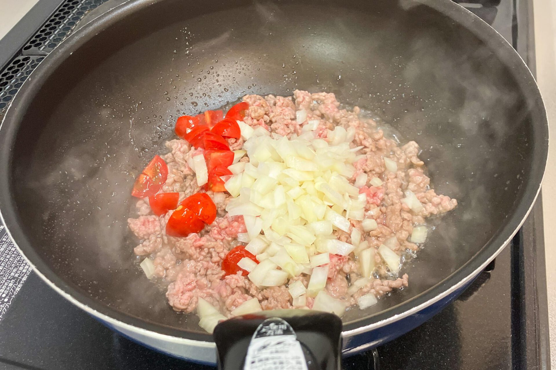 玉ねぎとミニトマトを加えて炒める